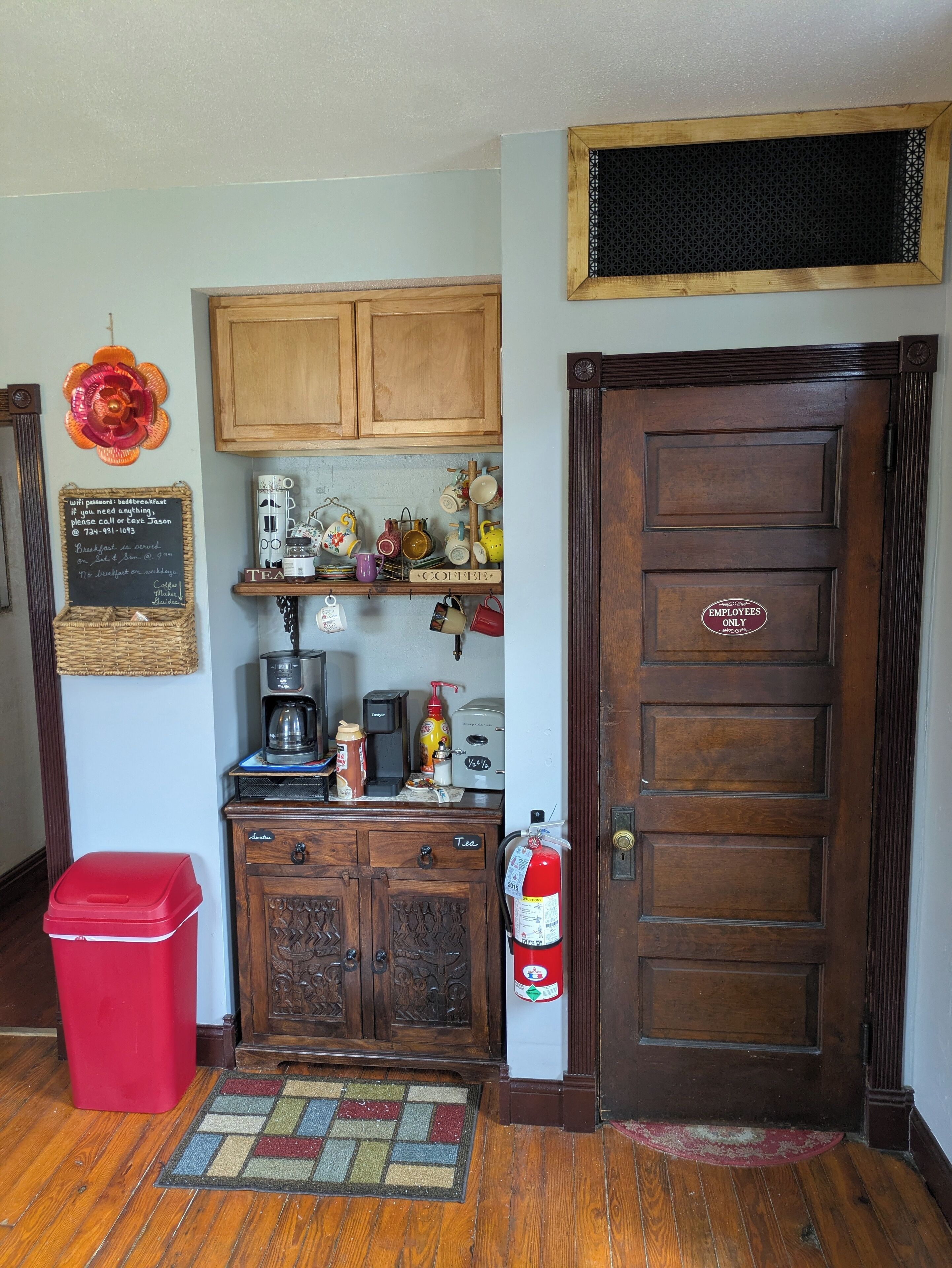 A kitchen with wooden cabinets, a coffee machine, and a fire extinguisher.