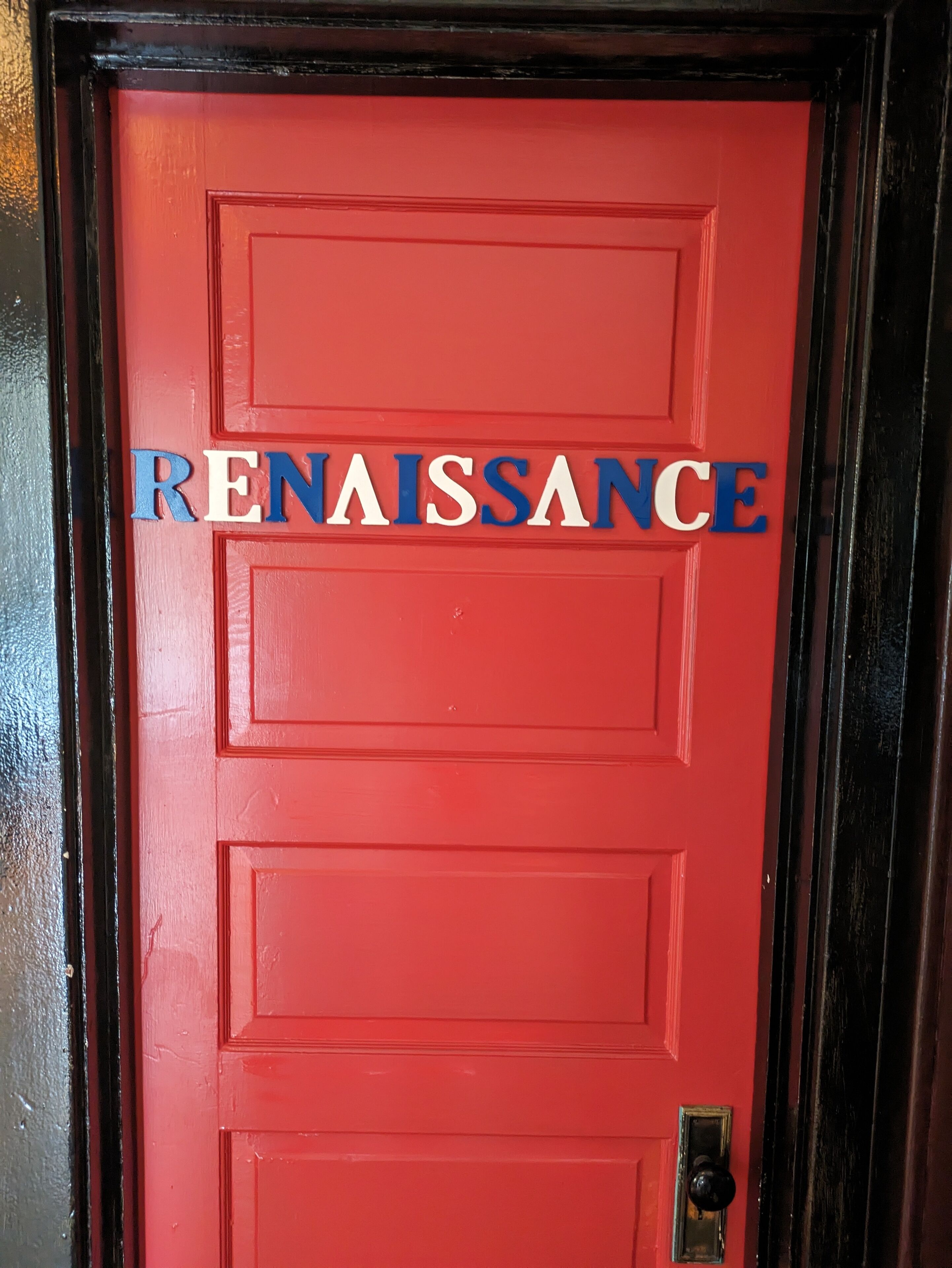 A red door with the word "RENAISSANCE" in blue and white letters.