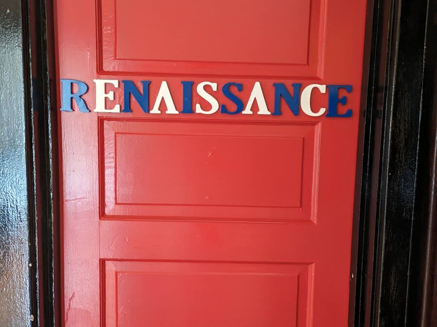 A red door with the word "RENAISSANCE" in blue and white letters.