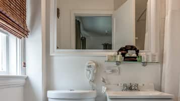 Une salle de bain équipée de toilettes, d’un lavabo, d’un miroir et d’un téléphone.