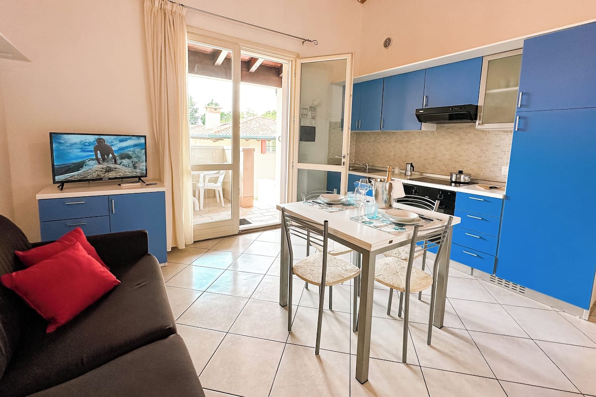 A compact living space with a dining area, kitchenette, and a TV in the living room.