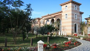 Un grande edificio con facciata simmetrica, finestre ad arco e una torre centrale.