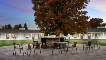 A patio area with outdoor seating and a stone fireplace.