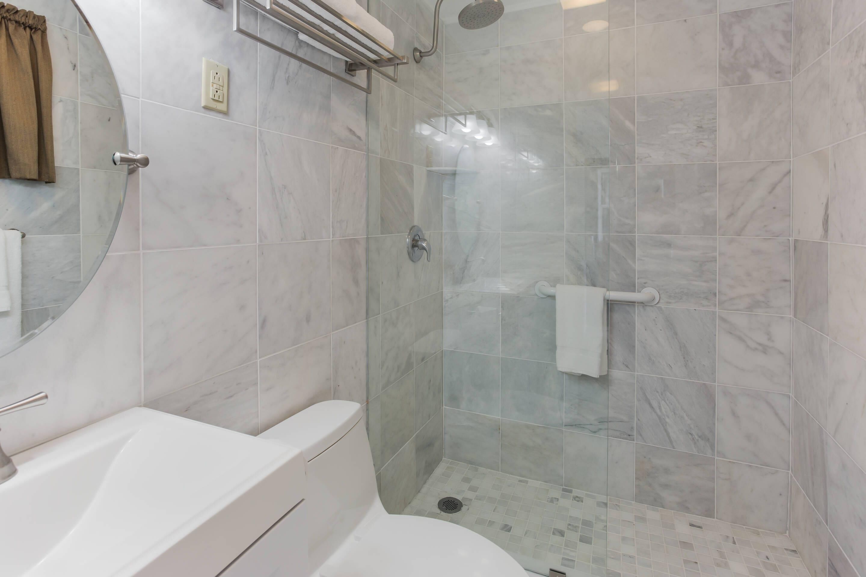 Ein modernes Badezimmer mit Badewanne, Toilette und einer gläsernen Duschkabine.