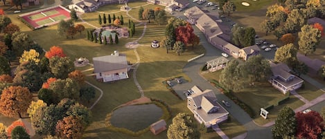 An aerial view of a residential area with multiple houses, a tennis court, and a golf course.