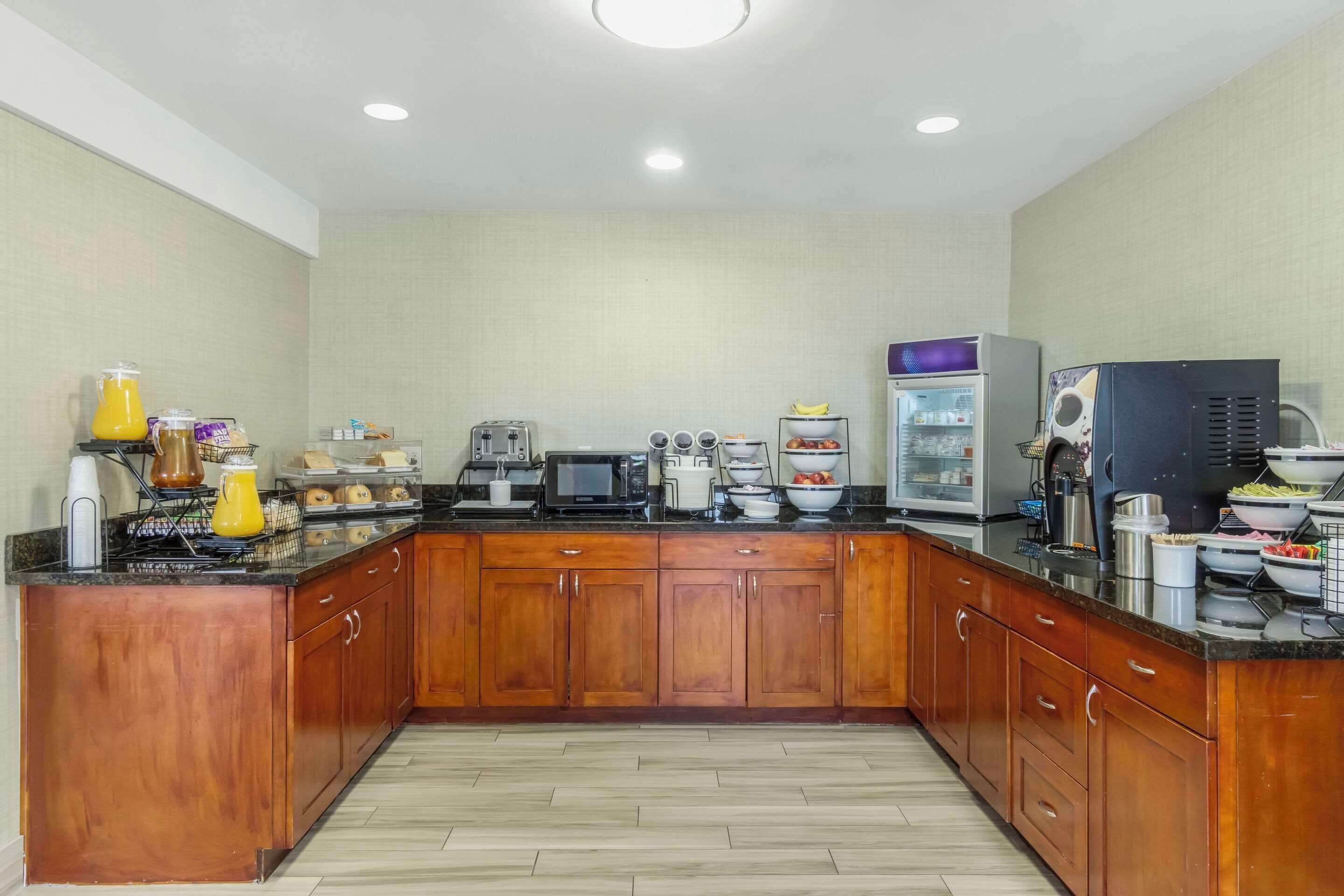 A kitchen with wooden cabinets, a microwave, toaster, and various appliances.