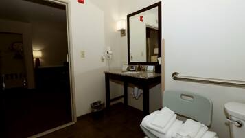 Casa de banho com lavatório, espelho, porta-toalhas e sanita.