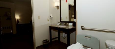 A bathroom with a sink, mirror, towel rack, and toilet.