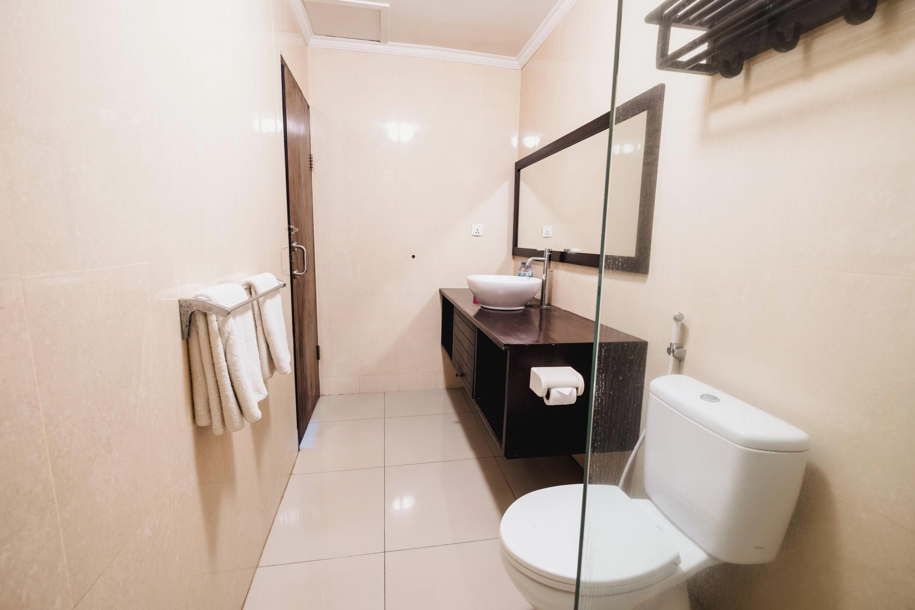 Une salle de bain moderne équipée de toilettes, d’un lavabo et d’un porte-serviettes.