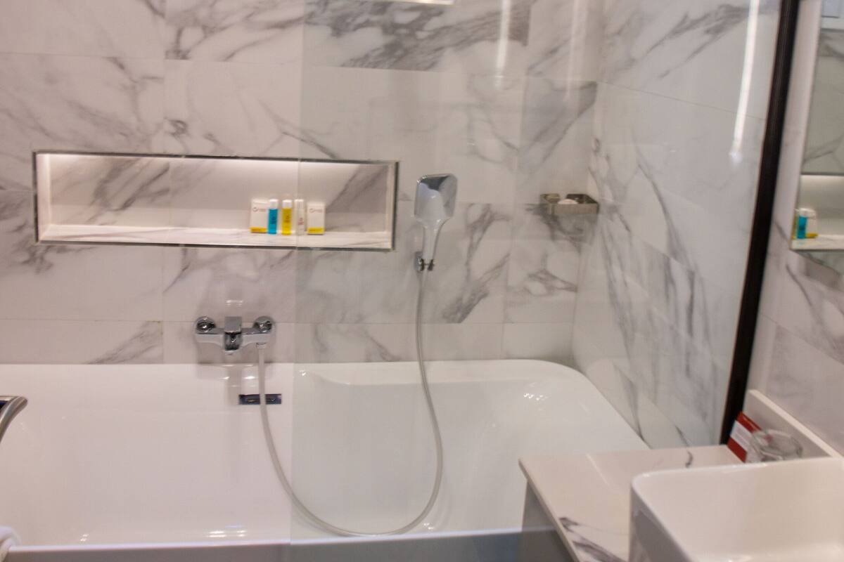 deluxe room | bathroom | shower, towels