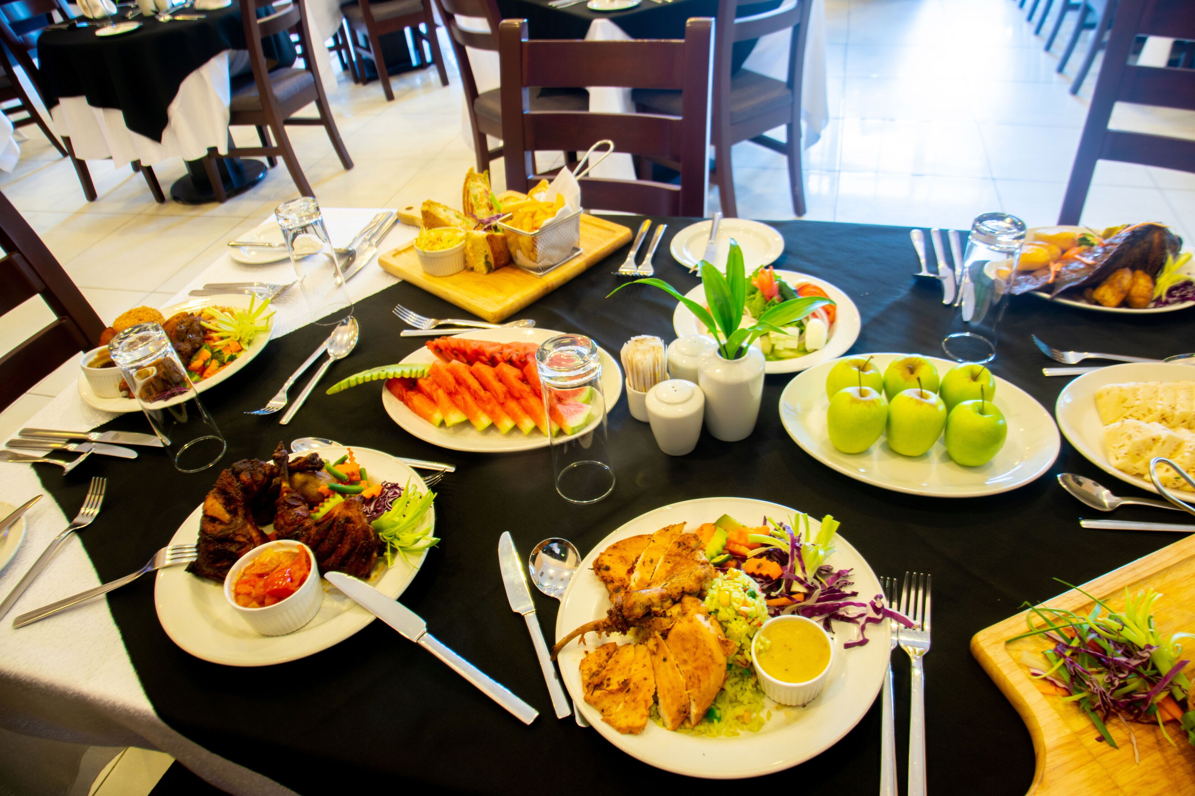Une table à manger dressée avec différents plats, couverts et condiments.