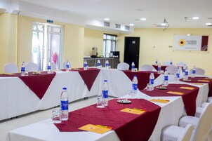 A conference room with tables set for a meeting, equipped with water bottles and nameplates.