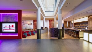 A modern lobby with a bar area, seating, and a digital display. - IntercityHotel Berlin Hauptbahnhof (Berlin)