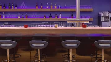 A bar area with a modern design, featuring a bar counter, stools, and a large hanging lamp.