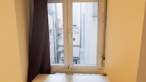 A room with a white desk, a chair, and a window with a view of buildings. - Pensión MYD La Estrella (Madrid)