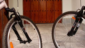 Dos bicicletas estacionadas frente a una puerta de madera con un cartel que indica una certificación.