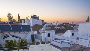 A rooftop terrace with a swimming pool, lounge chairs, and a wooden deck. - La Alcoba del Agua Hotel Boutique (Sanlucar de Barrameda)