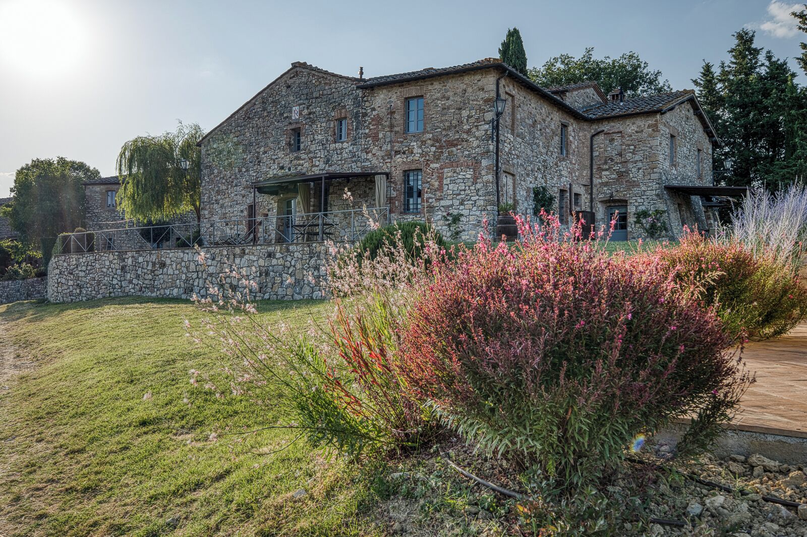 A stone building with a large front porch and a stone wall.