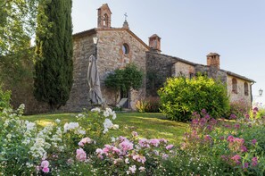 Un edificio de piedra con un jardín delantero.