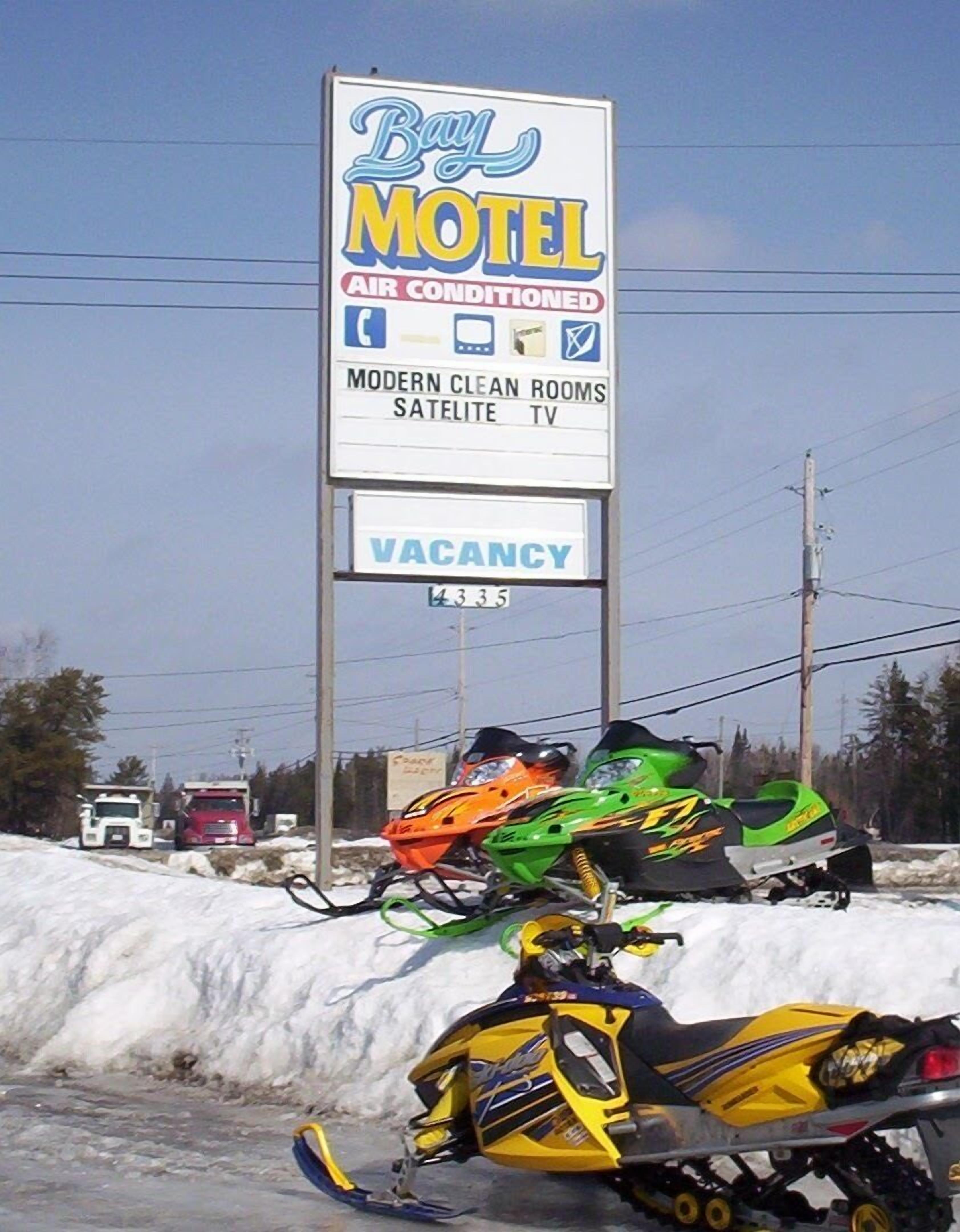 A motel sign advertising air conditioning, modern clean rooms, satellite TV, and a vacancy.