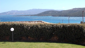 A coastal view with a stone wall, a lamp post, and a clear blue sea. - Le Saline Palau (Palau)