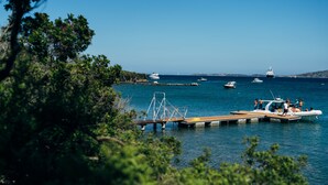 A marina with boats docked, a wooden pier, and a clear blue sky. - Le Saline Palau (Palau)