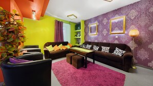 A modern living room with a sofa set, a coffee table, and a potted plant. - Moon Hostel Kraków (Kraków)