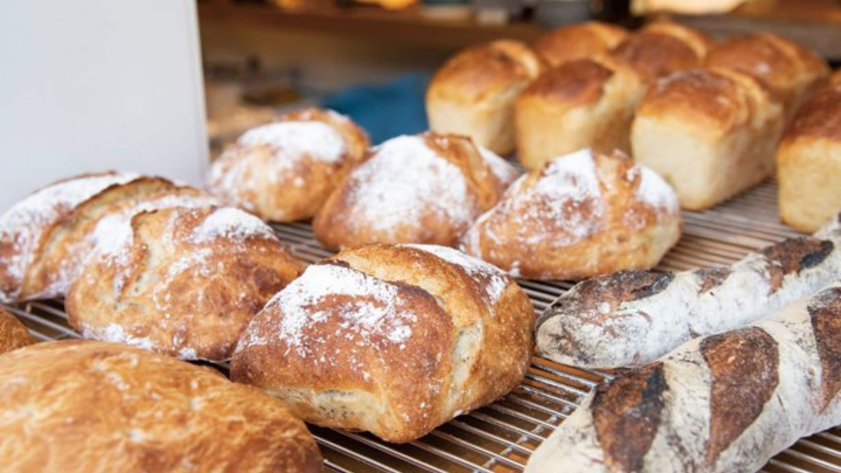 A variety of breads on a cooling rack.