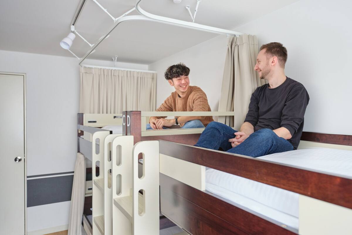A bunk bed room with two beds, a door, and a mirror.