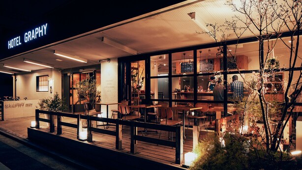 A hotel with a modern exterior, a covered outdoor seating area, and a visible sign for the hotel's name. - Hotel Graphy Nezu (Tokyo)