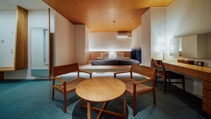 A modern hotel room with a wooden ceiling, a bed with a headboard, a desk with a chair, a round table, and a large mirror. - Hotel Graphy Nezu (Tokyo)