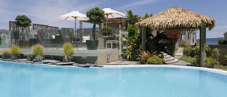 Piscine extérieure, parasols de plage, chaises longues