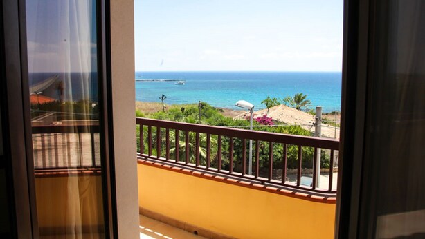 A balcony with a view of the ocean and beach.