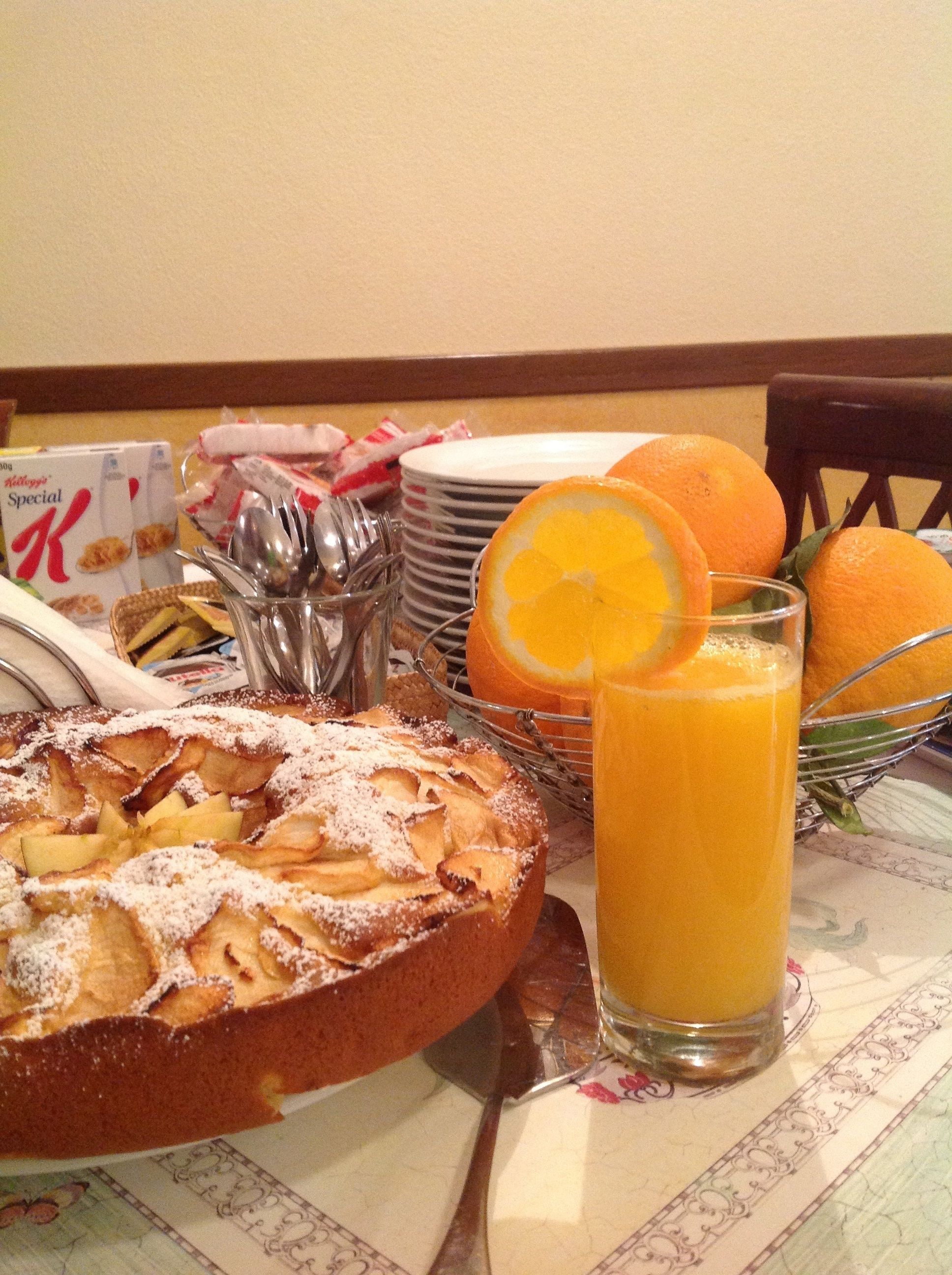 A breakfast setting with a fruit salad, a glass of orange juice, and a plate of food.
