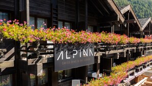 Um edifício de madeira com uma placa que diz 'ALPINA SWISS BIKE & SKI LODGE'.