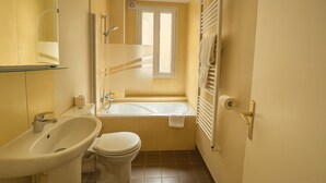 A compact bathroom with a sink, toilet, and bathtub. - Hôtel des Bains (Maisons-Alfort)