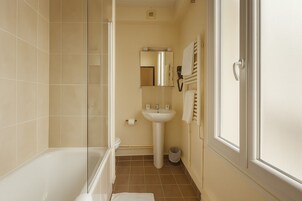 A bathroom with a bathtub, a sink, and a mirror.