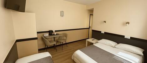 A hotel room with two beds, a desk, and a chair.