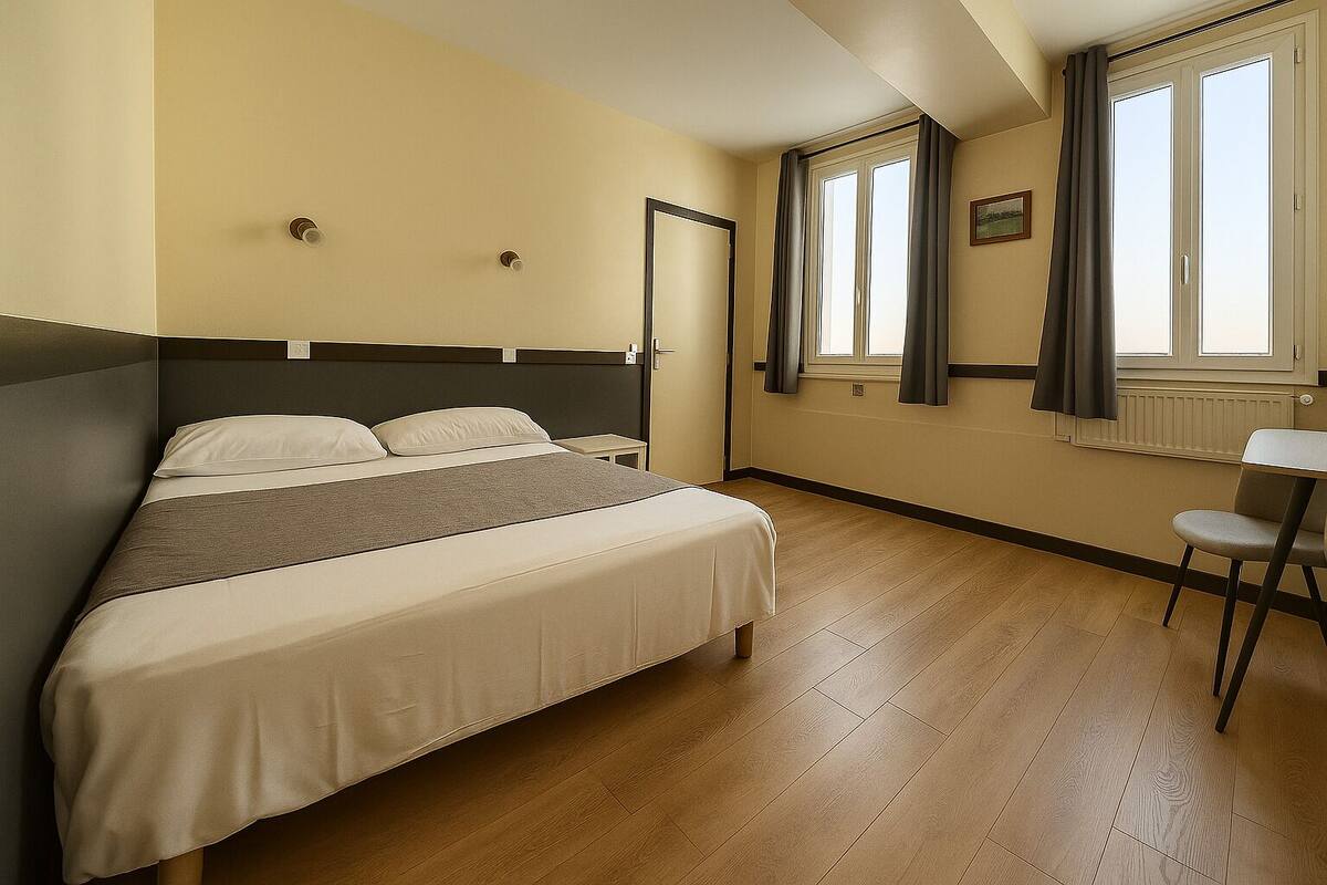 A bedroom with a bed, a chair, a window with curtains, and a radiator.