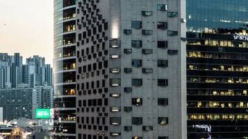 A hotel with a modern design, featuring a prominent 'HOTEL MANU' sign, a 2F cafe, and a craft beer option.