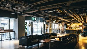 A modern bar area with leather seating, a bar counter, and exposed ductwork.