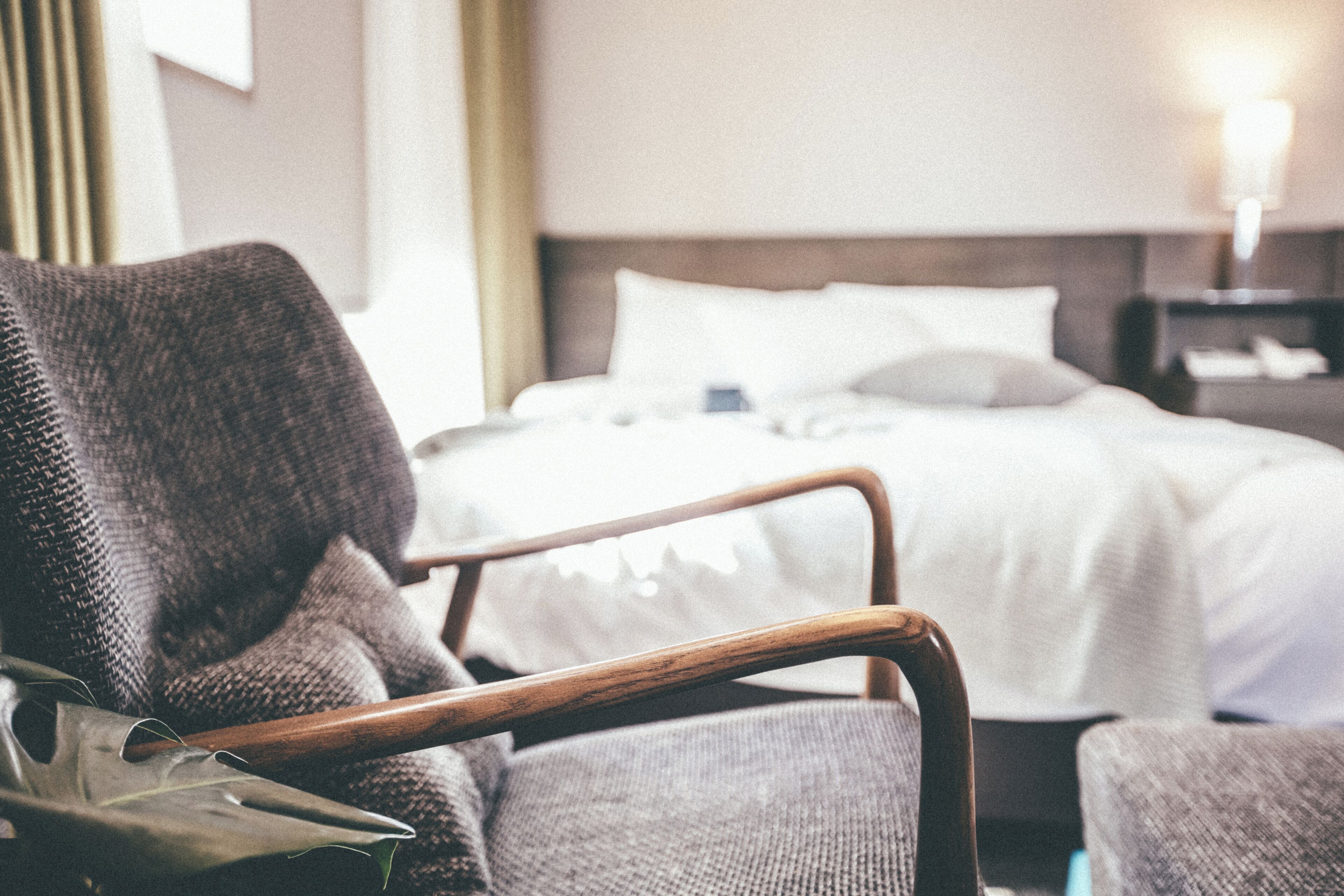 Ein Hotelzimmer mit Bett, einem Sessel und einem Nachttisch.