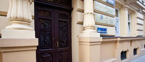 A building facade with ornate double doors, a sign for 'Moon Hostel', and a 'Kreditbank' sign.