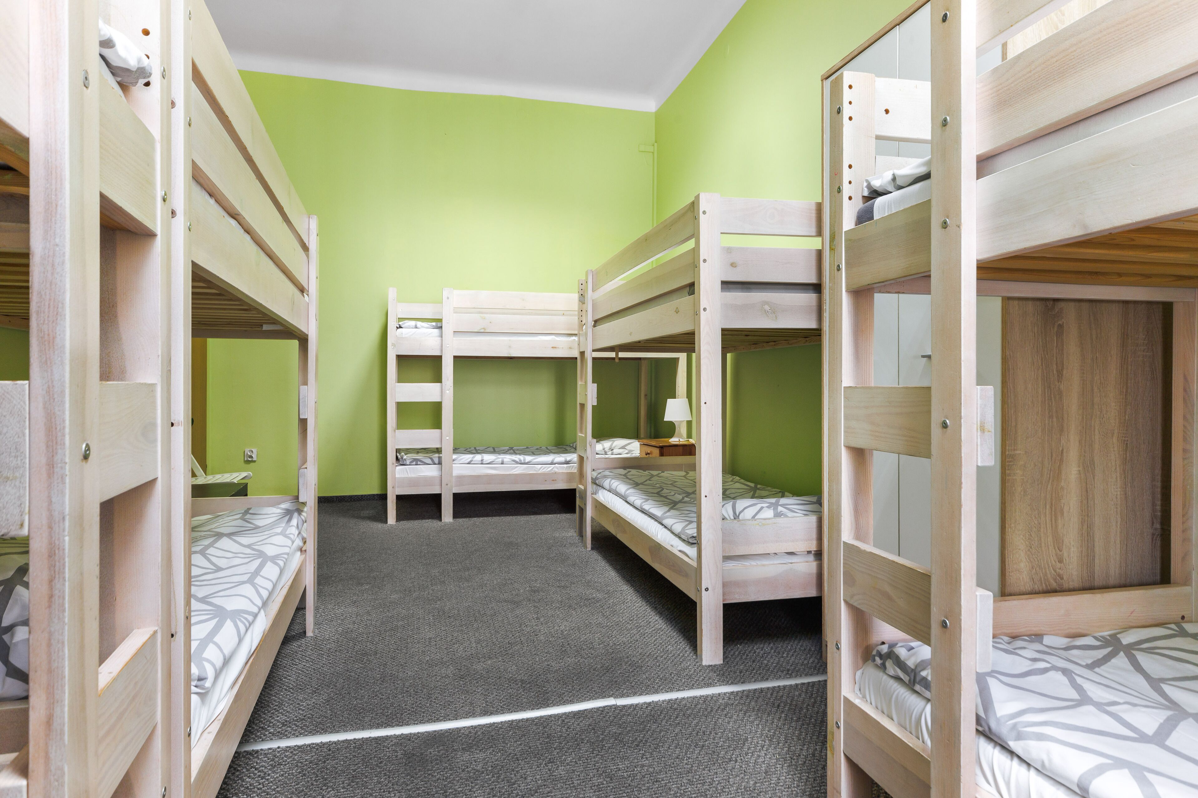 A room with bunk beds, green walls, and a carpeted floor.