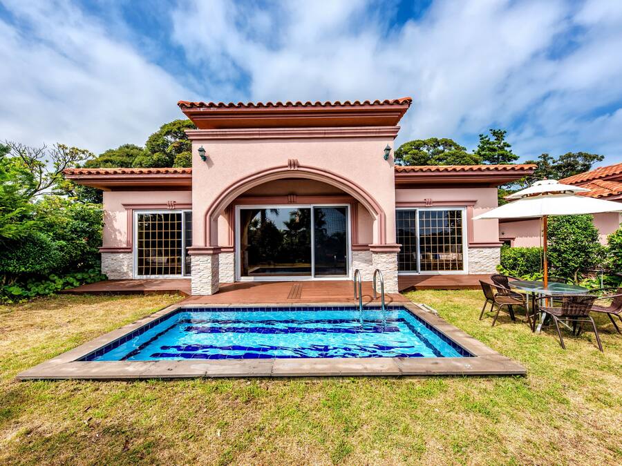 A house with a swimming pool, patio furniture, and a covered outdoor seating area.
