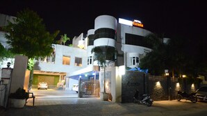 Un hôtel moderne, reconnaissable à son enseigne bien visible, doté d’une entrée sécurisée et d’un espace de stationnement.