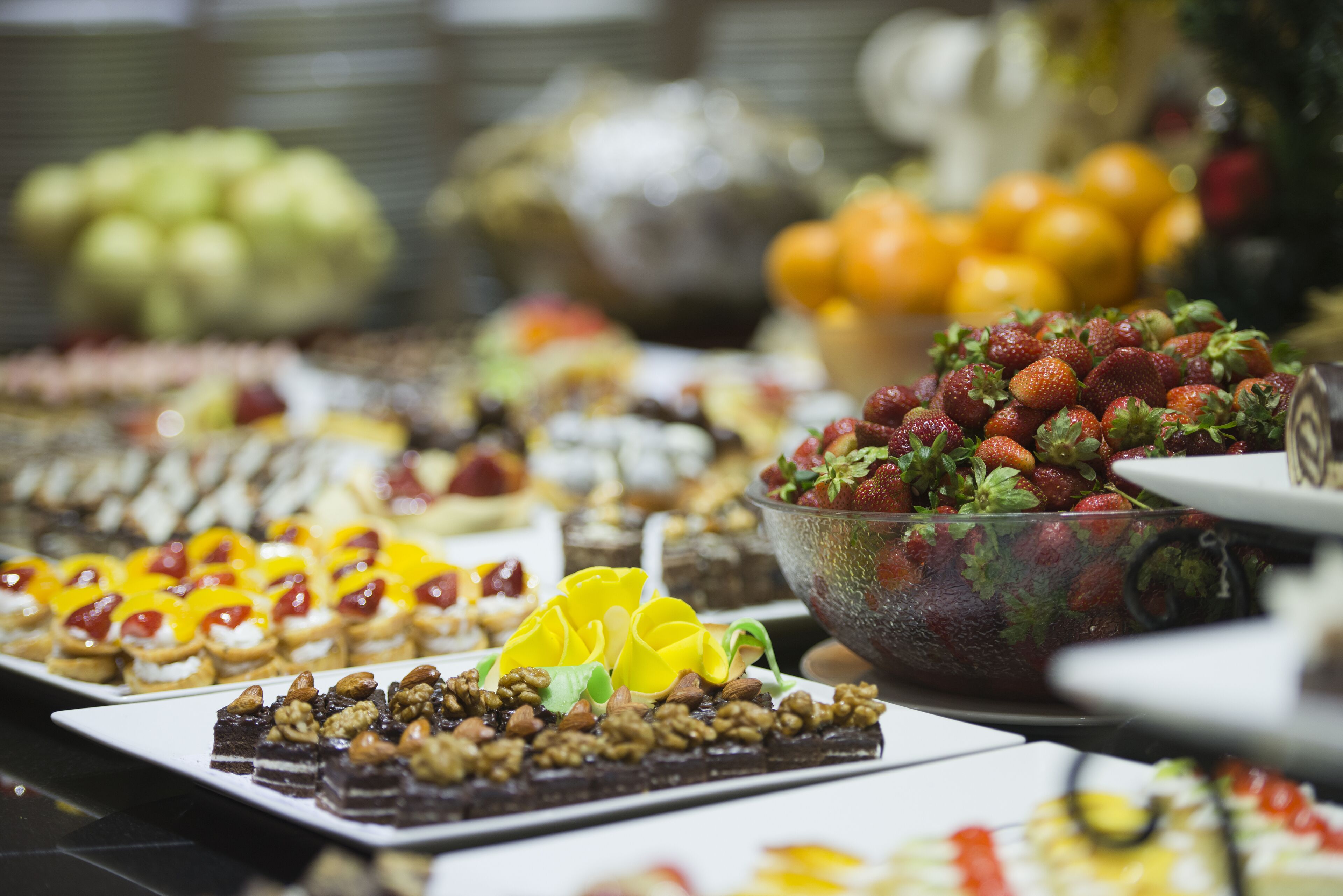 Un bufé con diversos postres y frutas.