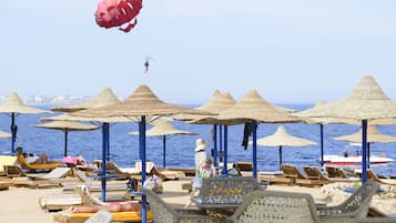 Playa privada, playa de arena blanca, camastros y sombrillas