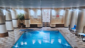 An indoor swimming pool with a clear water logo, tiled walls, and a checkered floor pattern. - The Heritage Hotel (Torquay)
