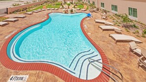 A swimming pool with a red border, lounge chairs, and a sign indicating a 4 ft no diving zone.